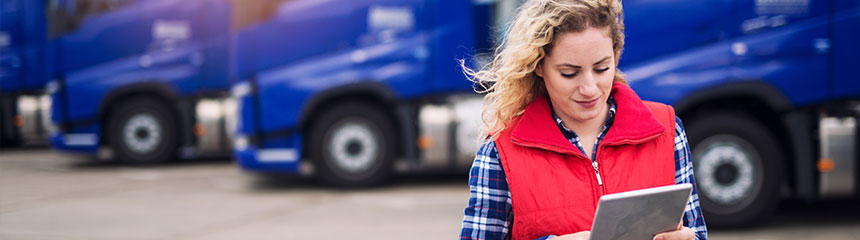 Female truck driver looking at tablet